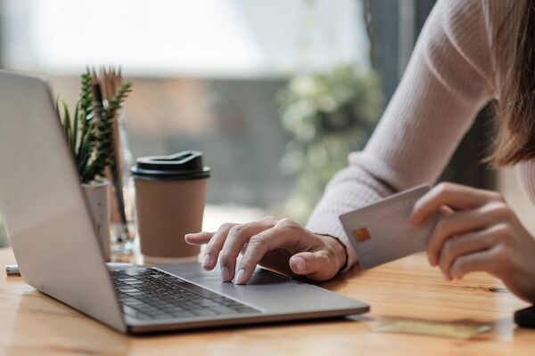 Frau im Cafe zahlt per Online Banking